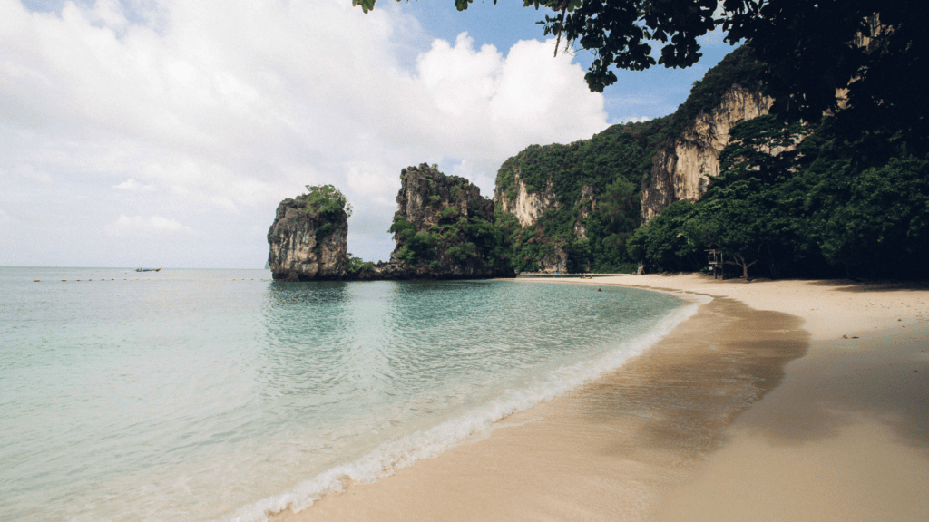 Praia com águas calmas e rochas