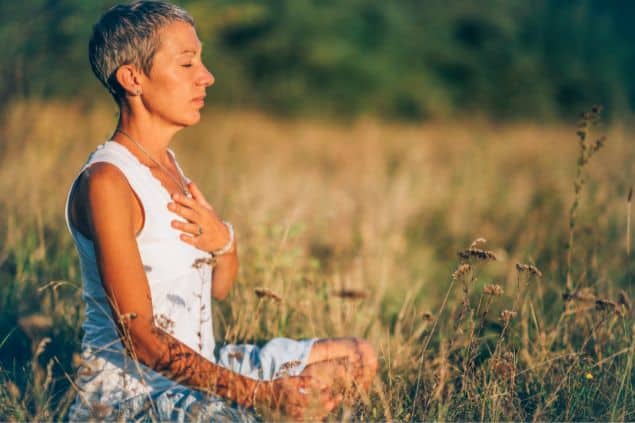 Mulher meditando em um matagal