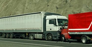 Dois caminhões se colidindo no acostamento de uma estrada