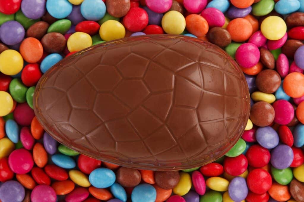 Ovo de chocolate em cima de confetes coloridos