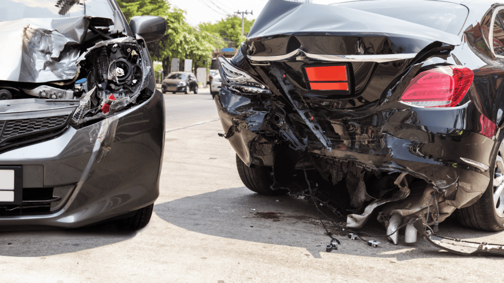 Dois carros pretos quebrados e amassados.