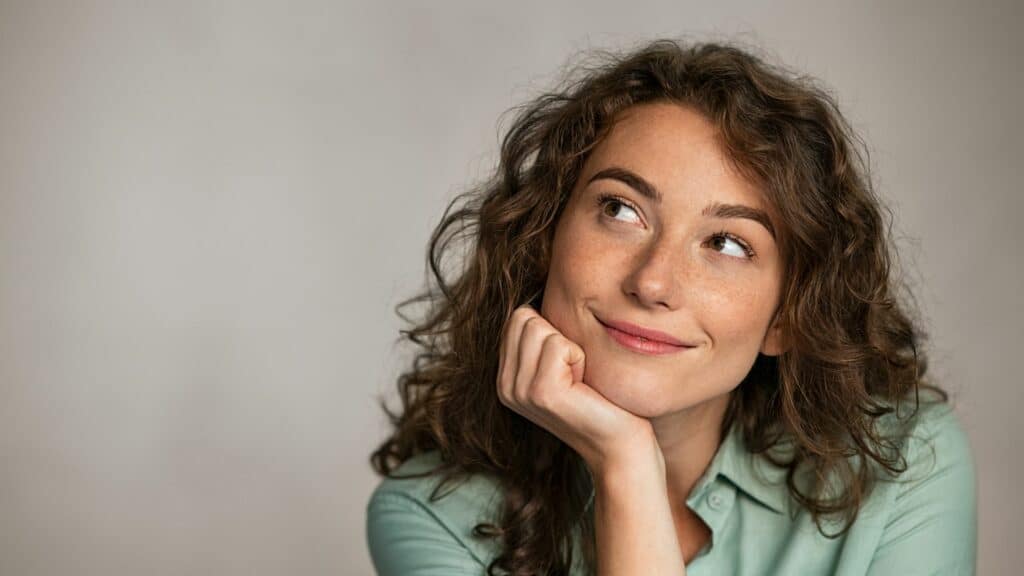 imagem de uma mulher refletindo e sorrindo