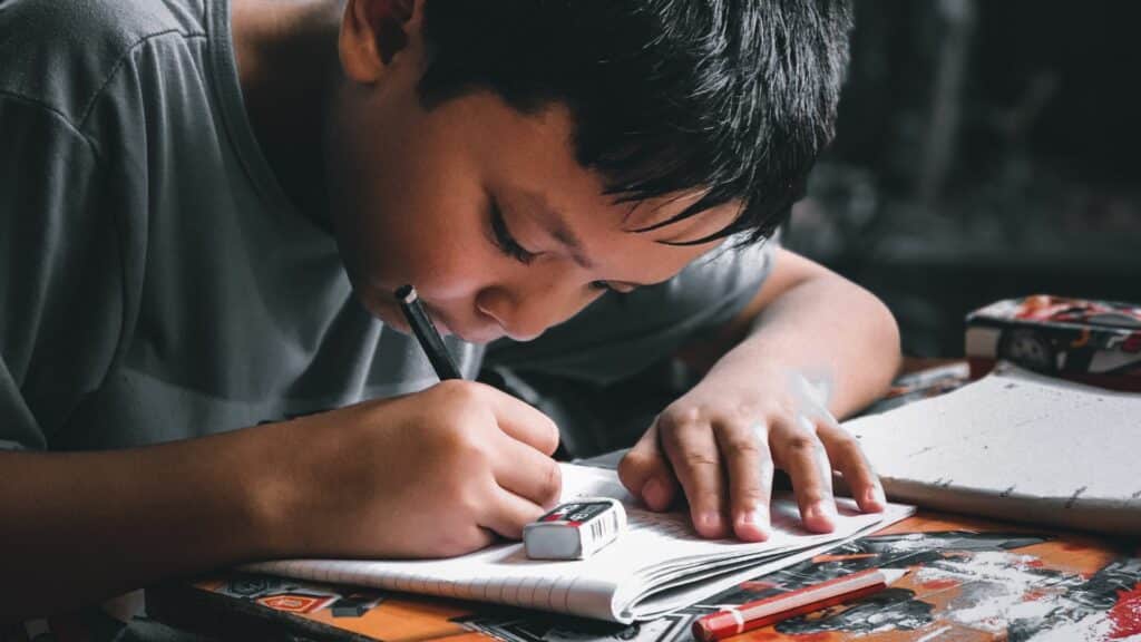 Imagem de um menino focado nos estudos