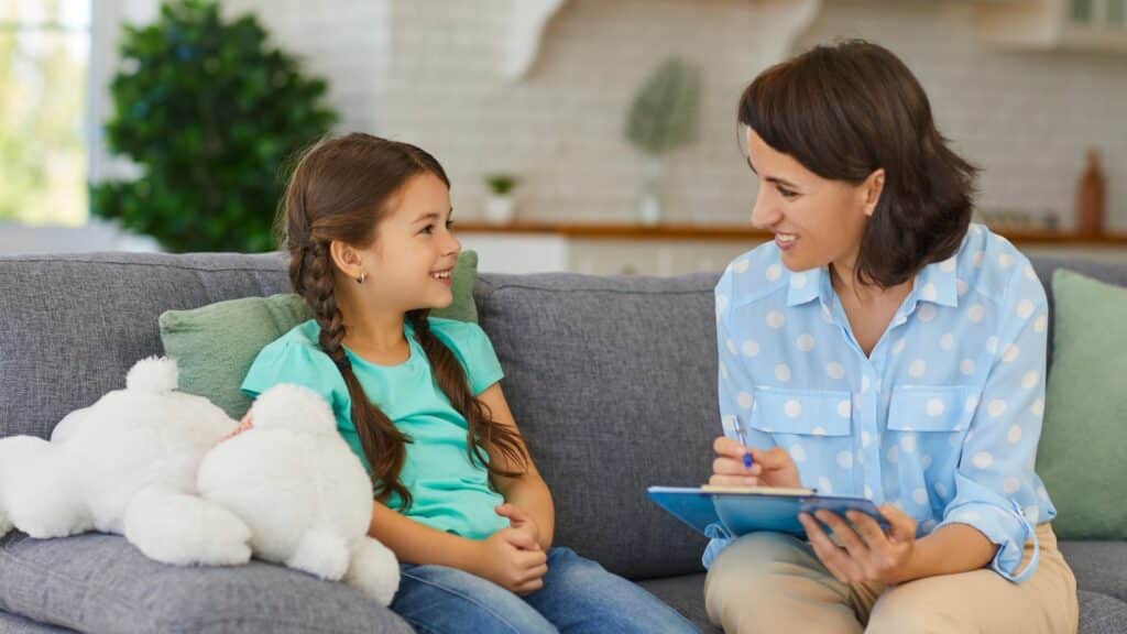 Imagem de uma menina conversando com uma mulher e ambas estão sorrindo