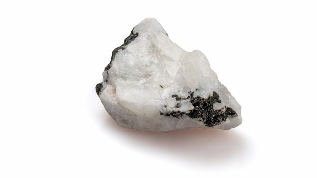 Foto de um cristal branco com partes negras. Pedra da Lua original.