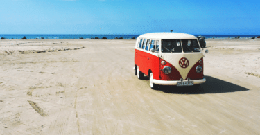 Kombi vermelha e branca na praia