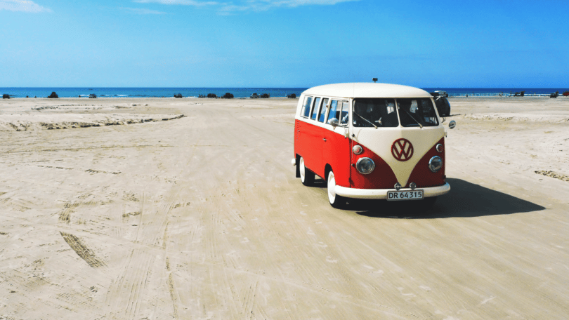 Kombi vermelha e branca na praia