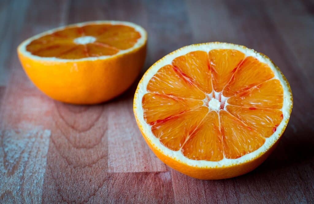 Duas metades de uma laranja sobre uma mesa de madeira