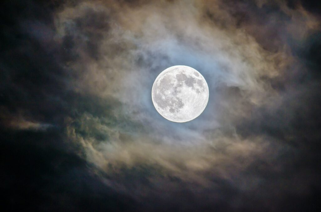 Lua entre uma fina camada de nuvens.
