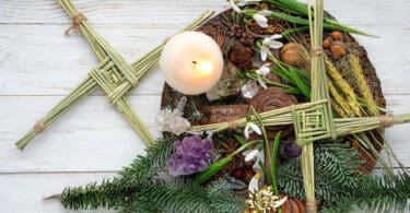 Altar Wicca com símbolos do outono, velas, folhagens, entre outros elementos.
