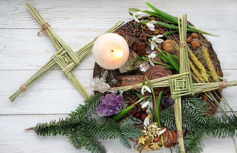 Altar Wicca com símbolos do outono, velas, folhagens, entre outros elementos.