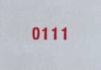 Numeral 0111 escrito em vermelho, em uma parede.