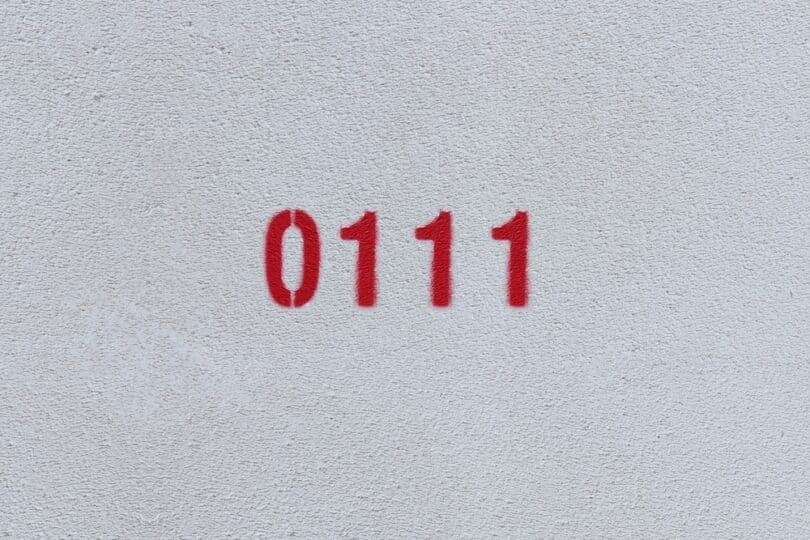 Numeral 0111 escrito em vermelho, em uma parede.