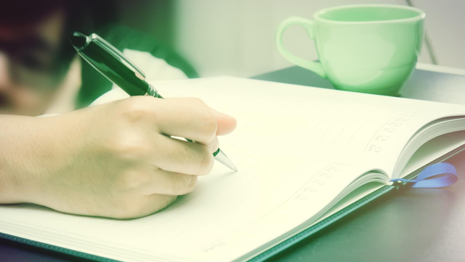 Write activity (A girl hand holds a pen and write on a book) with morning lighting