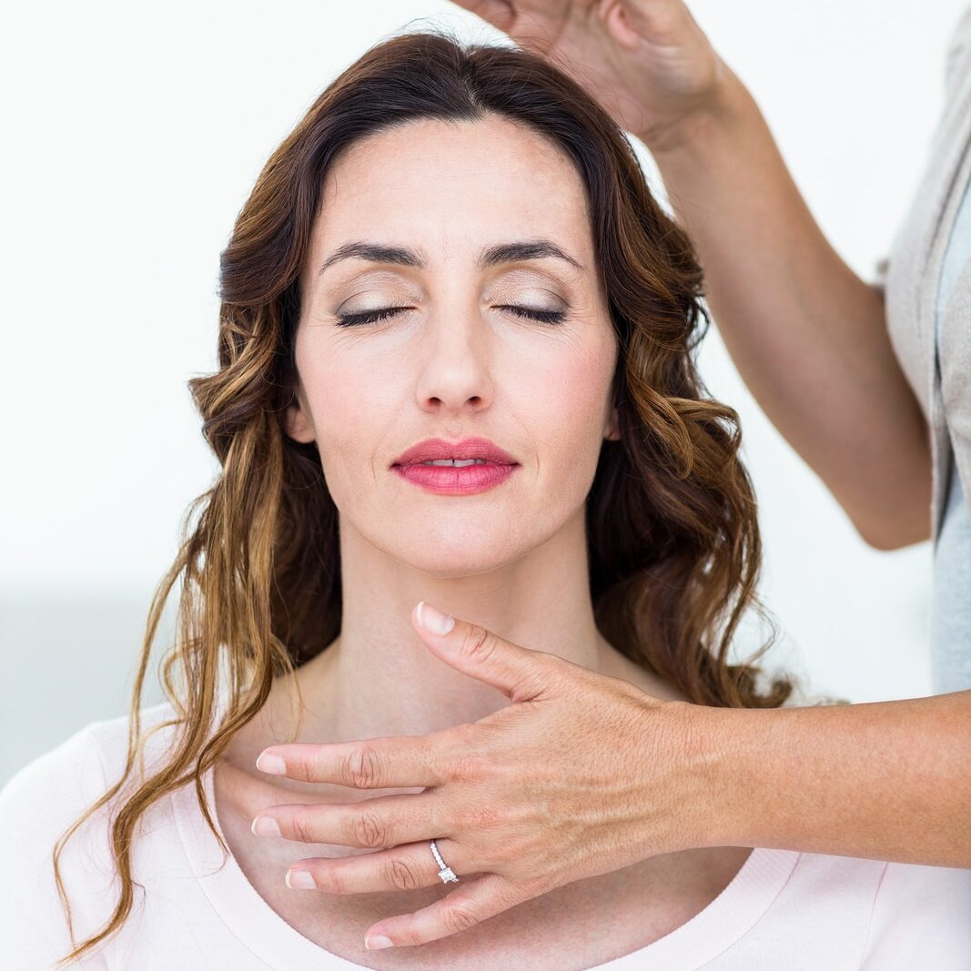 Calm woman receiving reiki treatment on white background