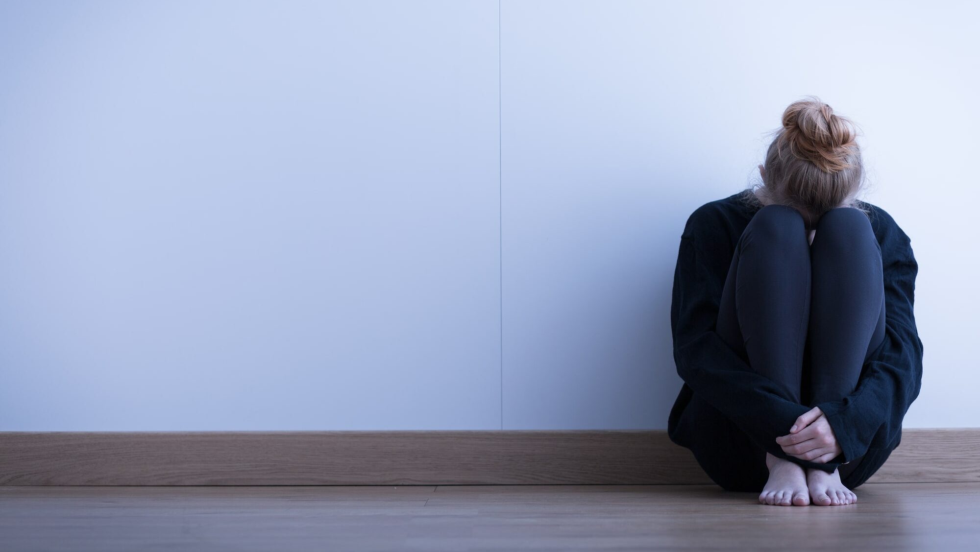 Girl sitting curled up on the floor