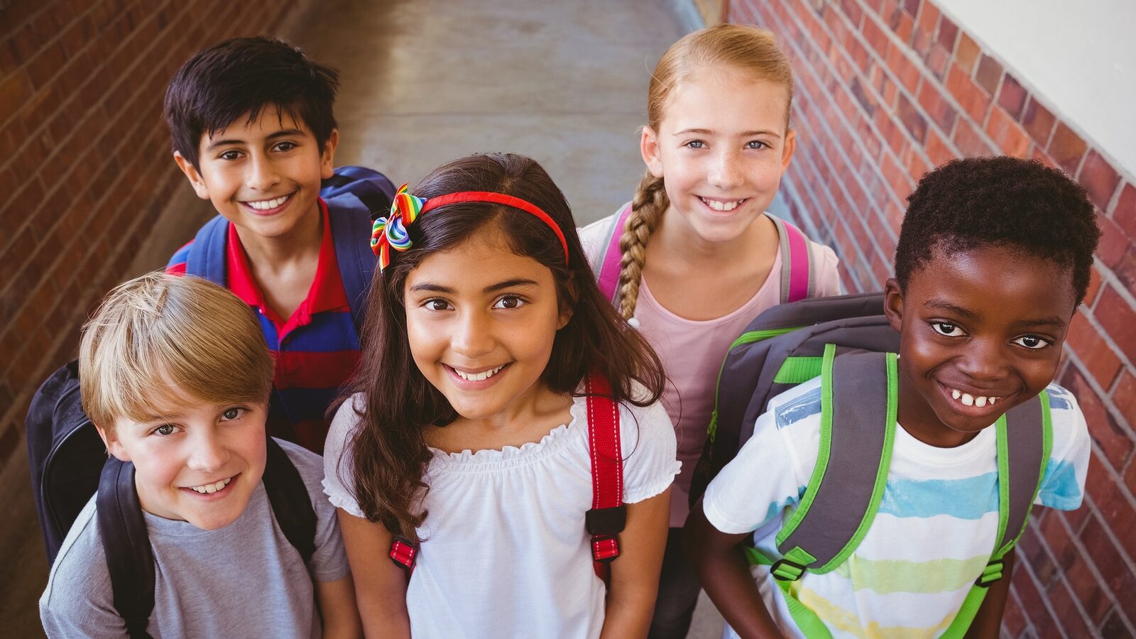 Portrait of smiling little school kids in school corridor