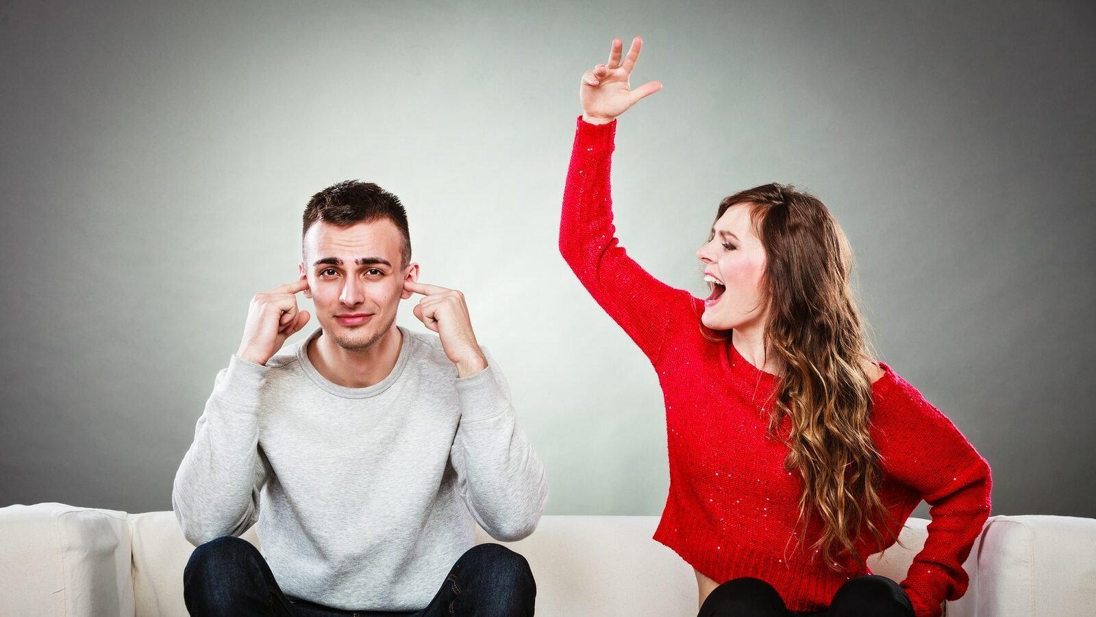 couple having argument - conflict bad relationships. Angry fury woman screaming man closes his ears.