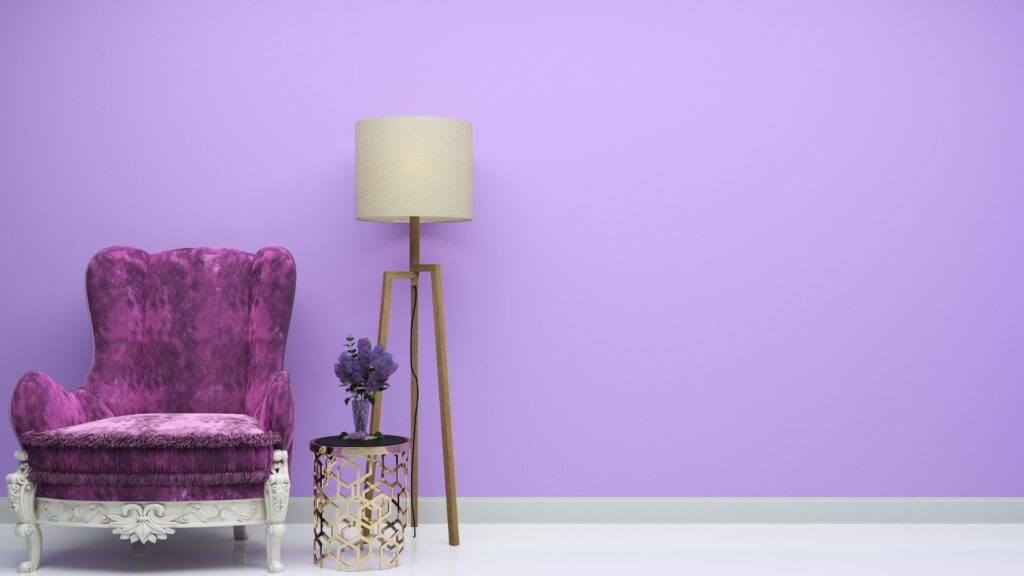 Imagem de uma sala lilás, com uma poltrona lilás e lavanda em uma mesinha