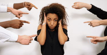 Pessoas apontando os dedos para uma mulher negra