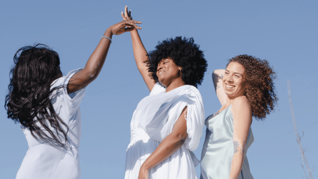 Mulheres negras sorrindo e ao fundo, o céu azul