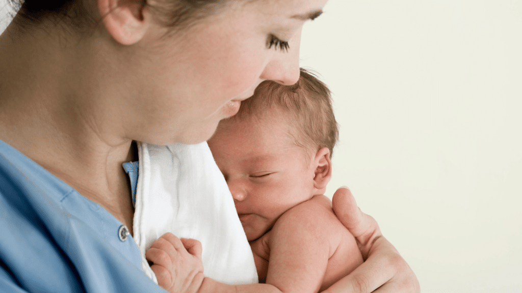 Mulher segurando bebê recém nascido no colo