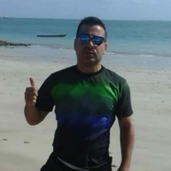 Foto do poeta Nilo Deyson em uma praia.