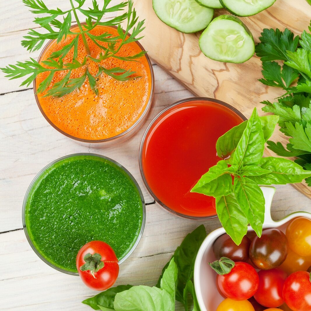 Fresh vegetable smoothie on wooden table. Tomato, cucumber, carrot. Top view