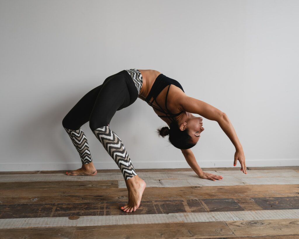 Mulher praticando uma pose de ashtanga yoga, em movimento, sobre o chão.