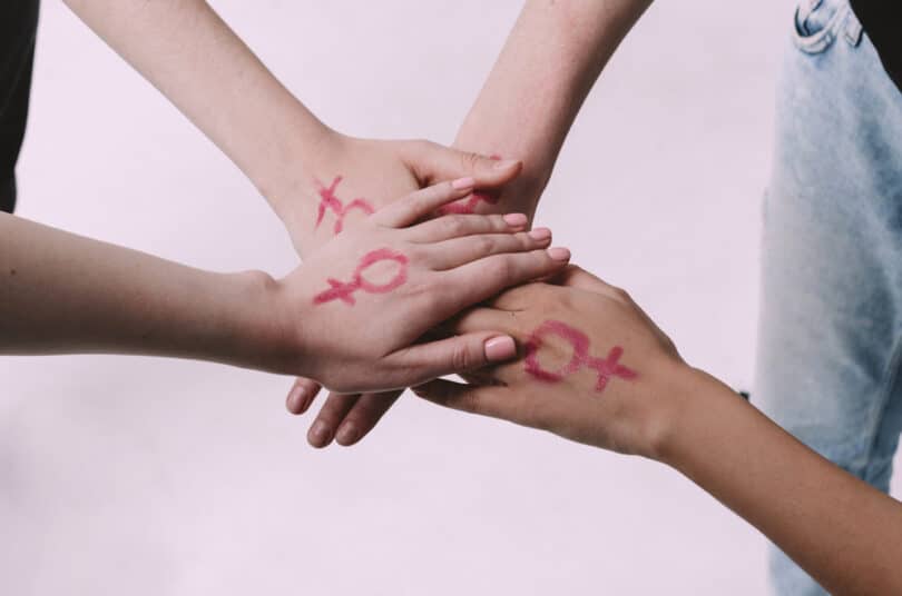 Várias mulheres com o símbolo feminino na mão