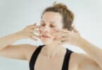 Mulher fazendo massagem facial em si mesma com a ponta dos dedos