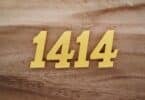 Número 1414 escrito de dourado em superfície de madeira