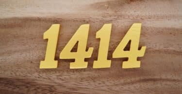 Número 1414 escrito de dourado em superfície de madeira
