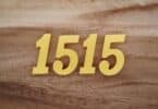 Número 1515 em algarismos dourados sobre uma superfície de madeira