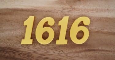 Número 1616 dourado sobre superfície de madeira
