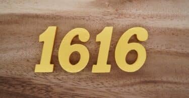Número 1616 dourado sobre superfície de madeira
