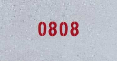 Número 0808 estampado de vermelho numa parede branca