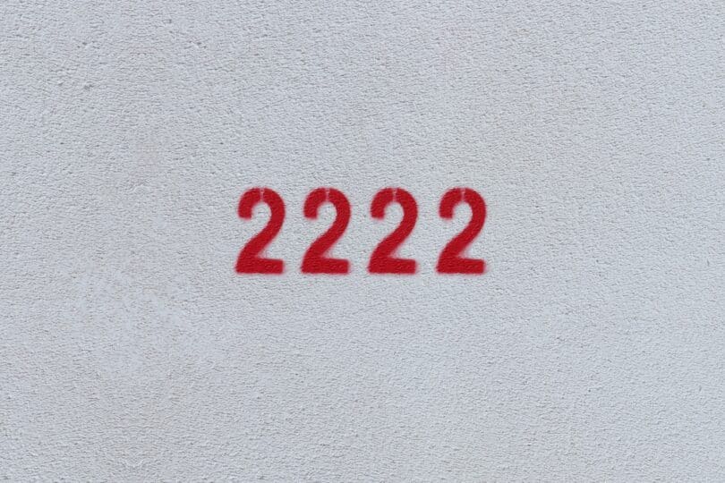 Número 2222 estampado de vermelho em parede branca