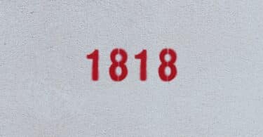 Número 1818 estampado de vermelho numa parede branca