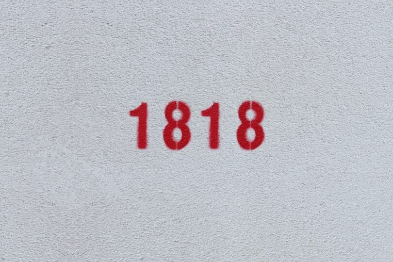Número 1818 estampado de vermelho numa parede branca