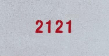 Número 2121 estampado de vermelho numa parede branca
