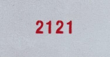 Número 2121 estampado de vermelho numa parede branca