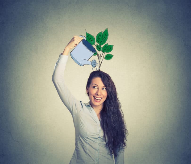 Mulher regando uma planta na cabeça dela