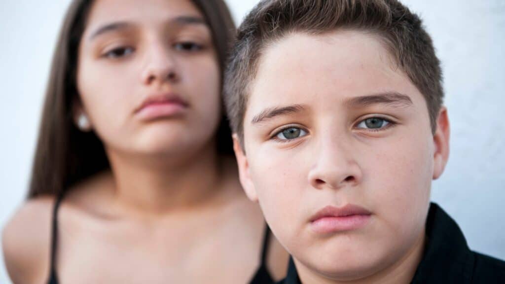 Imagem de duas crianças olhando sério para frente, como se estivessem encarando alguém