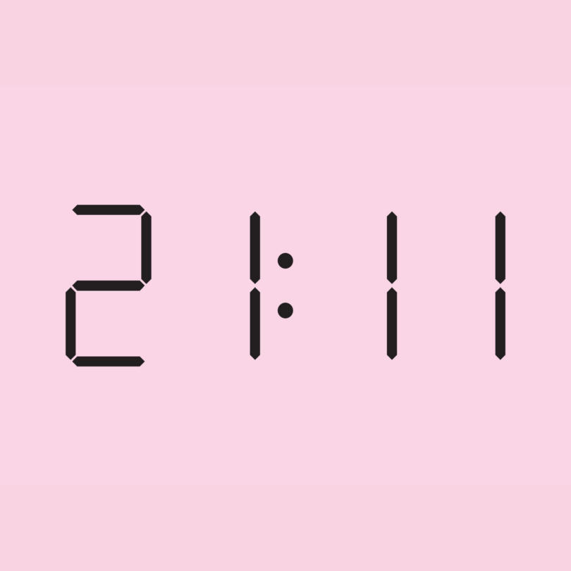 Horário 21h11 em algarismos digitais sobre um fundo cor de rosa