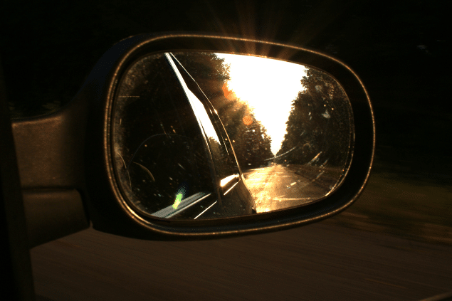 Retrovisor de carro mostrando um caminho para trás