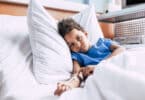 Menino doente deitado em cama com acesso no braço