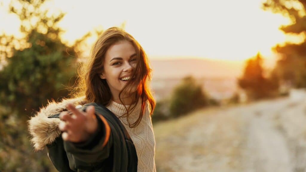 Imagem de uma mulher sorrindo com a mão estendida para frente