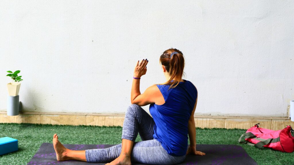 Imagem de uma mulher fazrendo a postura de Yoga Ardha Matsyendrasana