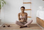 Mulher negra sentada em posição de yoga